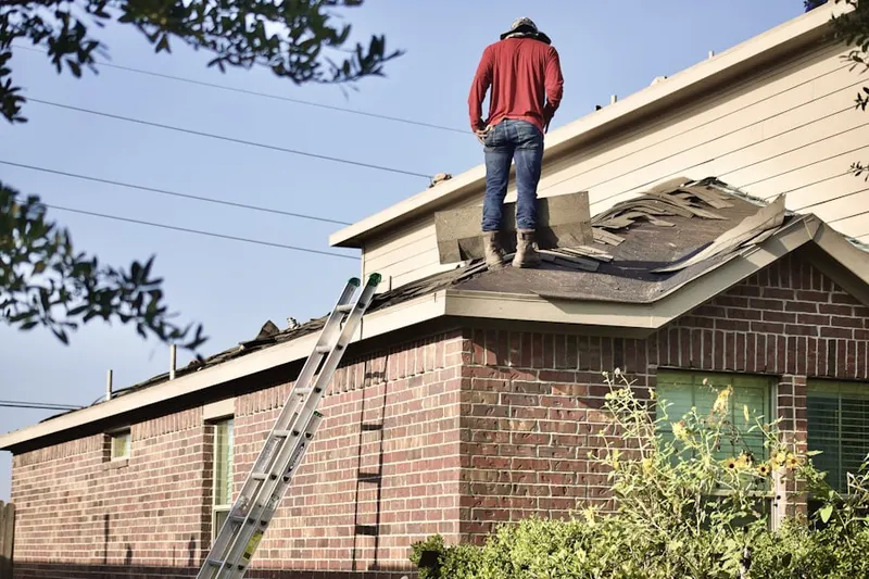 Professional roofer working on a residential roof in River Terrace